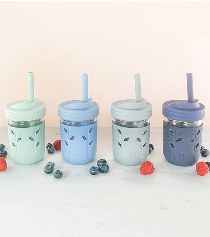 Four 4oz glass tumblers with silicone covers, lids and straws, varying in color.