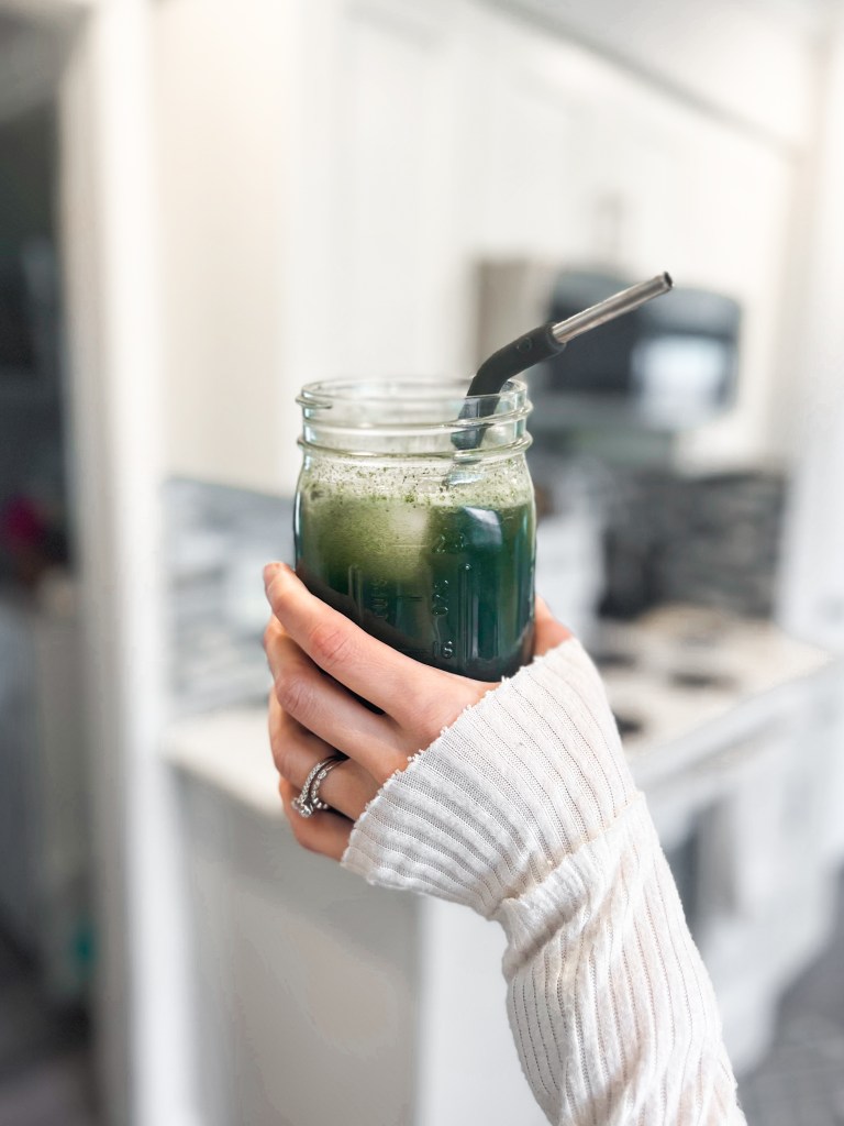 Hand holding mason jar of greens drink (Arbonnes GreenSynergy)
